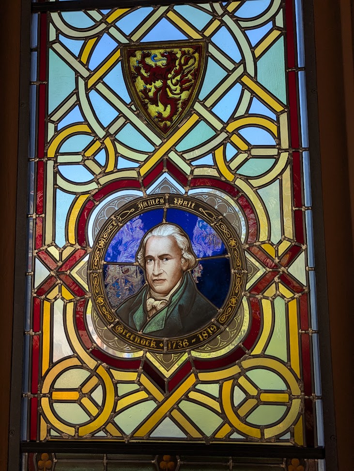 A stain glass window with a picture of James Watt